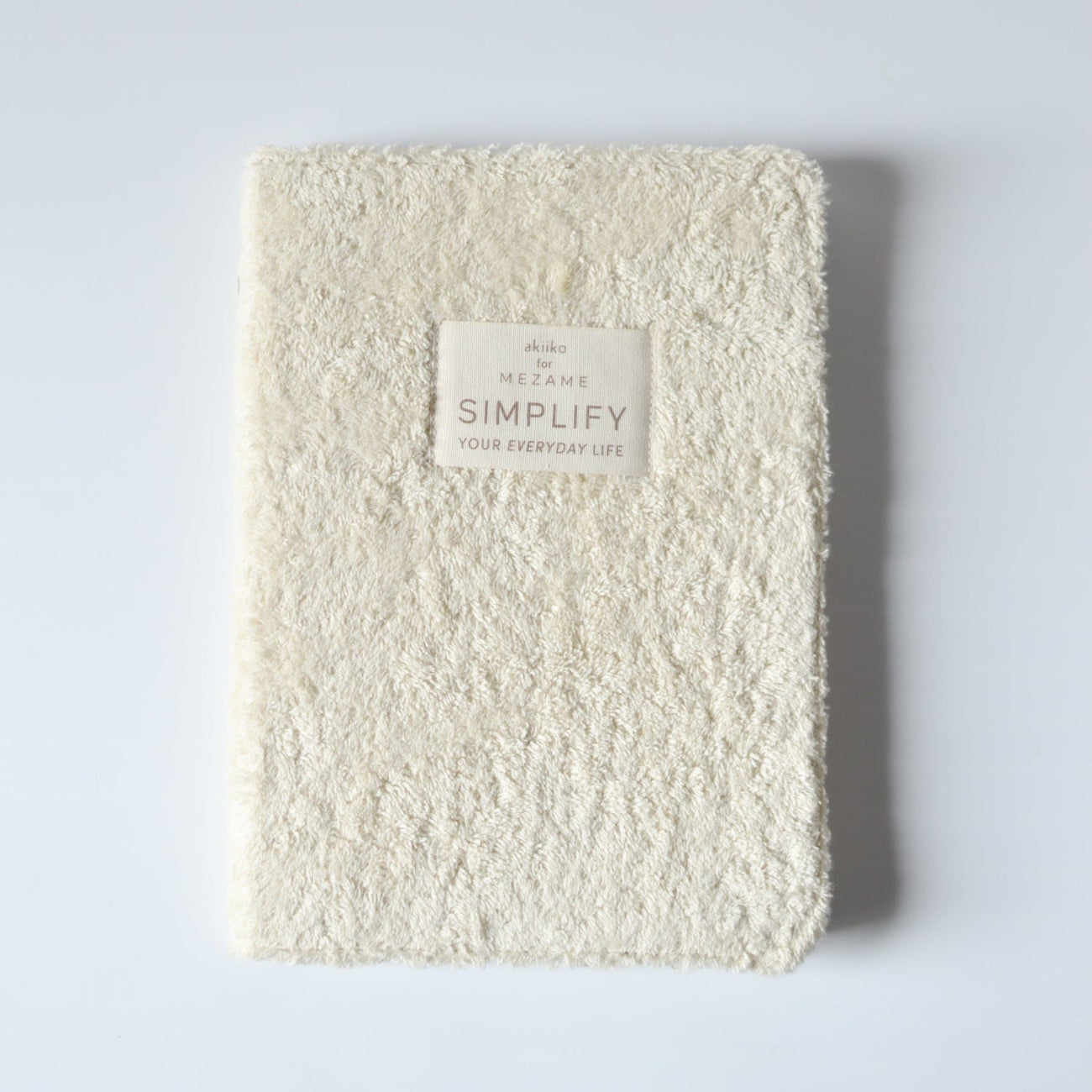 White textured notebook journal with a label on a light gray background