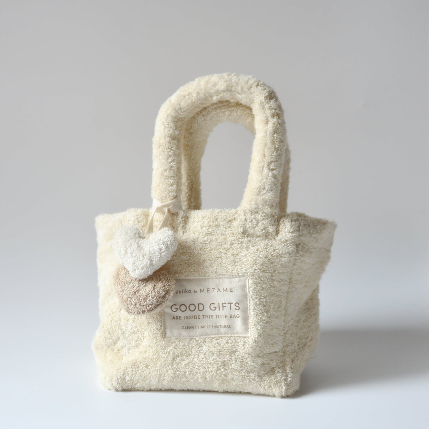 Fluffy cream-colored tote bag with a heart detail on a light gray background