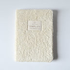 White textured notebook journal with a label on a light gray background