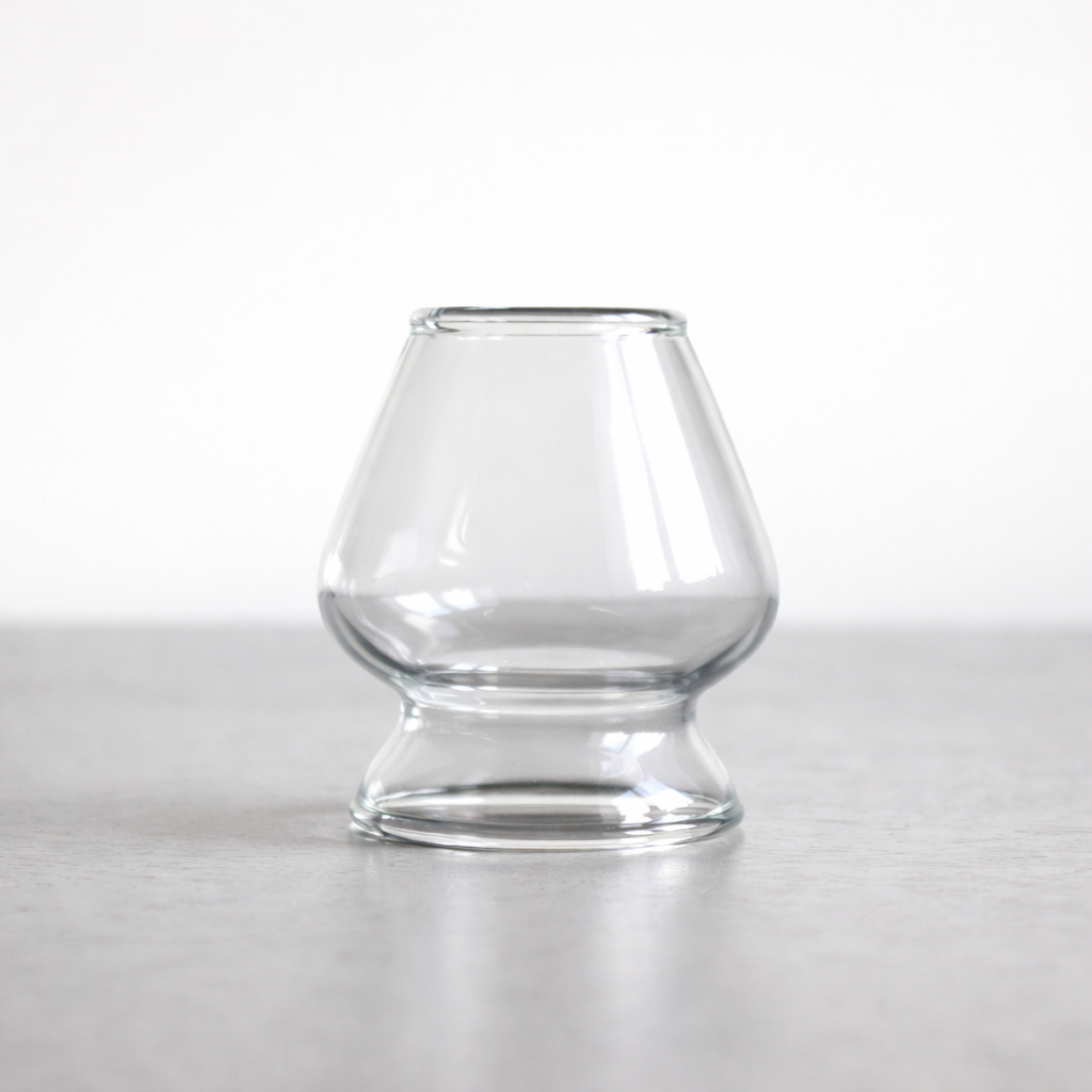 Clear glass Japanese bamboo whisk holder on a white background