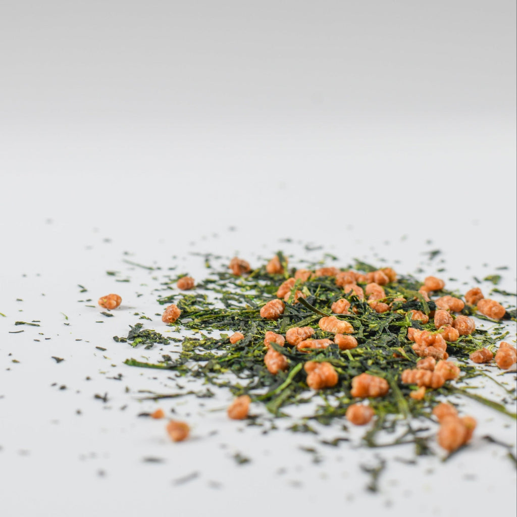 Small pile of Mezame genmaicha green tea leaves on a light gray background