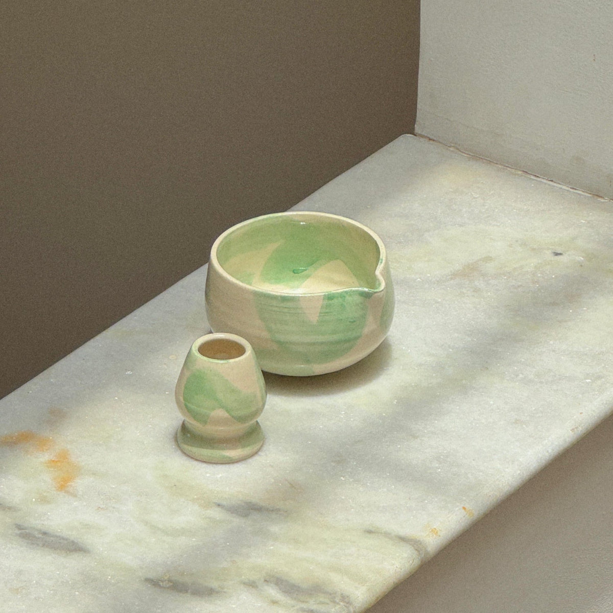 Two ceramic bowls on a marble surface with a neutral background