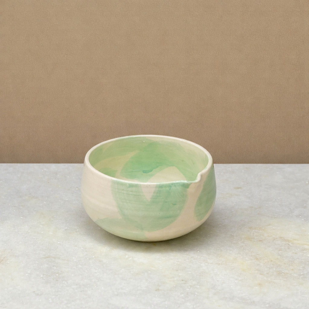 Mezame Ceramic Matcha bowl / Chawan with green and white pattern on a beige background