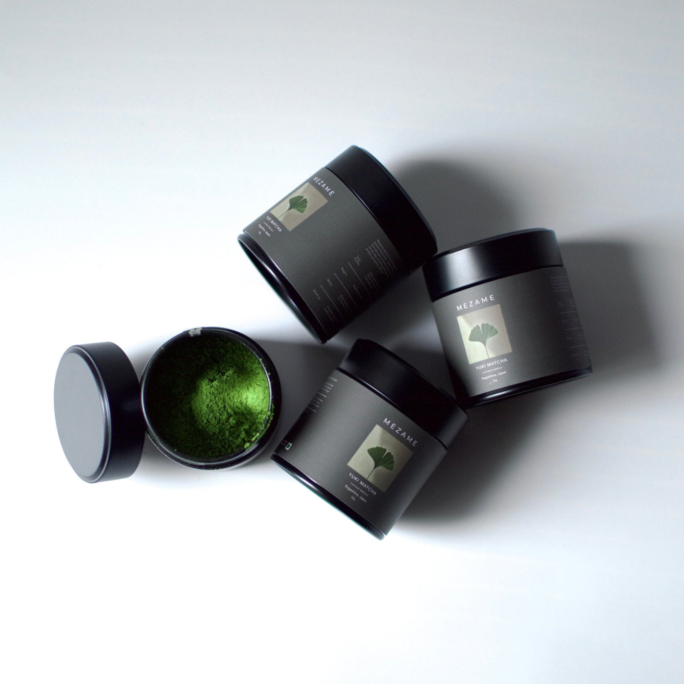 Black Mezame yuki ceremonial matcha with green powder on a white background