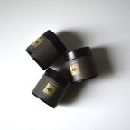 Three mezame yuki matcha black tins with on a white background